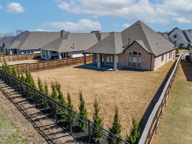 view of yard with a fenced backyard, a residential view, and a patio