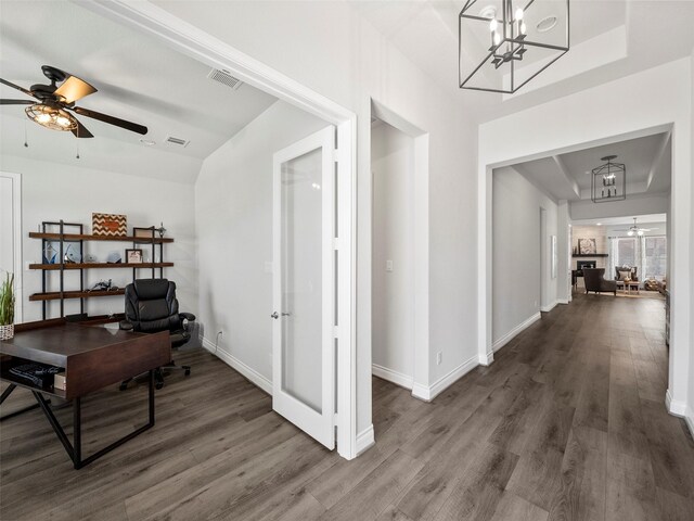 hall with french doors, hardwood / wood-style floors, a tray ceiling, and a notable chandelier