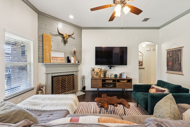 living room with a fireplace, hardwood / wood-style floors, ceiling fan, and crown molding