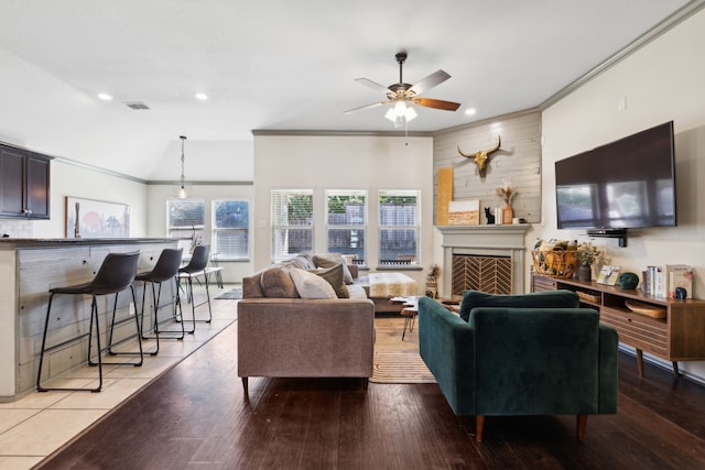 living room with crown molding, ceiling fan, lofted ceiling, and hardwood / wood-style flooring