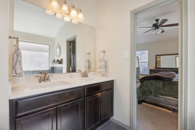 bathroom with vanity, lofted ceiling, ceiling fan, and a healthy amount of sunlight