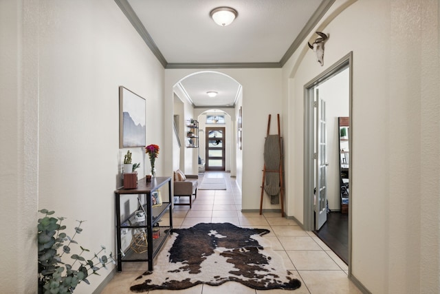 hall with crown molding and light tile patterned flooring