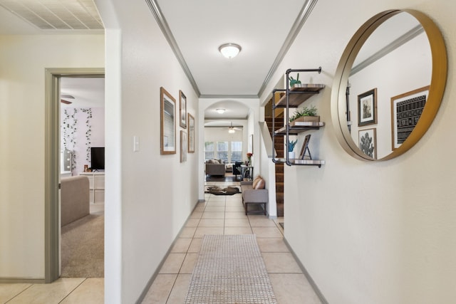 hall featuring crown molding and light tile patterned floors