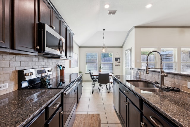 kitchen with decorative backsplash, stainless steel appliances, vaulted ceiling, decorative light fixtures, and dark stone countertops