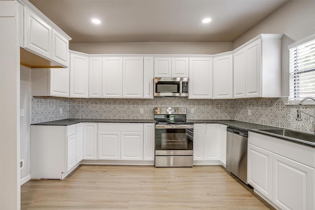 716 SE 7th Ave, Mineral Wells, TX 76067 - kitchen with appliances with stainless steel finishes, a sink, dark countertops, white cabinetry, and recessed lighting