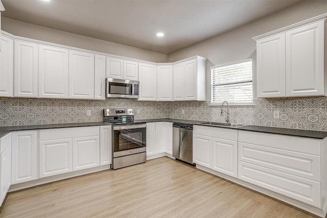 716 SE 7th Ave, Mineral Wells, TX 76067 - kitchen with stainless steel appliances, a sink, dark countertops, white cabinetry, and recessed lighting
