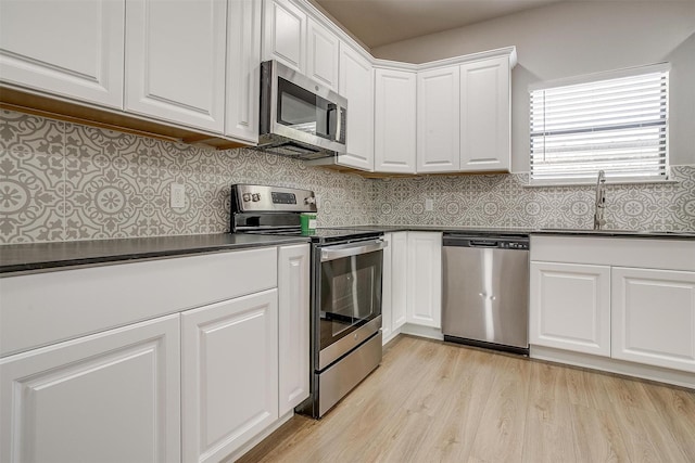 716 SE 7th Ave, Mineral Wells, TX 76067 - kitchen featuring stainless steel appliances, a sink, dark countertops, and white cabinetry