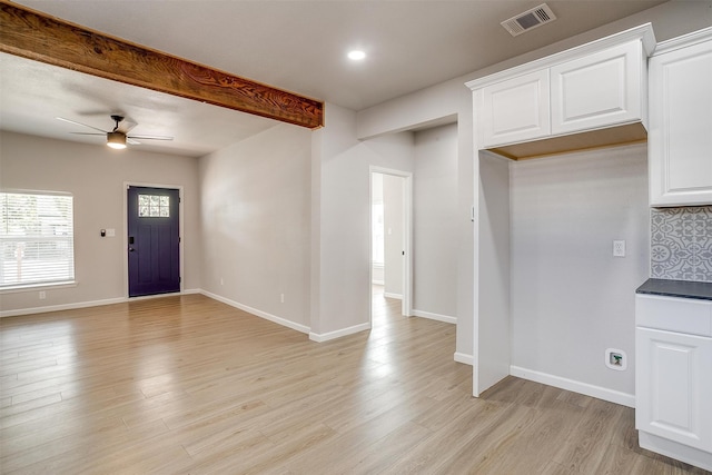 interior space featuring decorative backsplash, white cabinets, light wood-type flooring, and ceiling fan