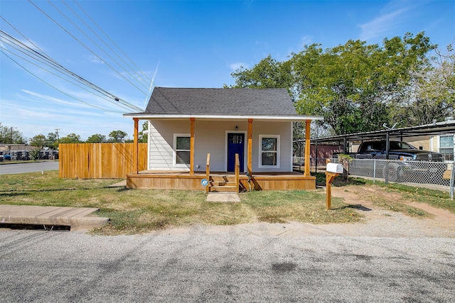 view of front of property with a porch, a front lawn, and a carport