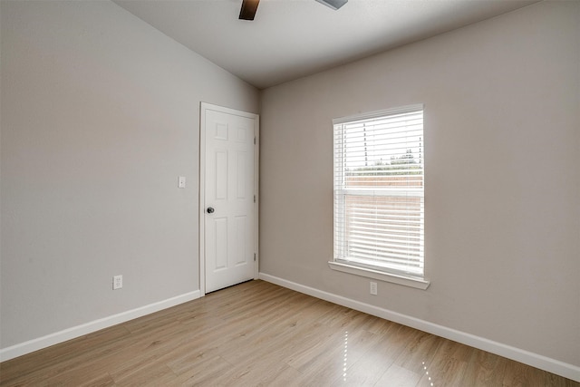 spare room featuring light hardwood / wood-style floors, vaulted ceiling, and ceiling fan