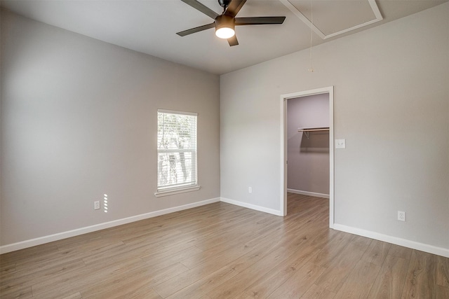 empty room with ceiling fan and light hardwood / wood-style flooring