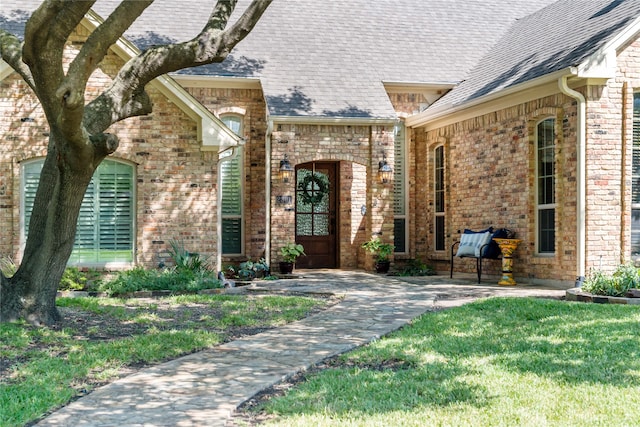 view of exterior entry with a yard