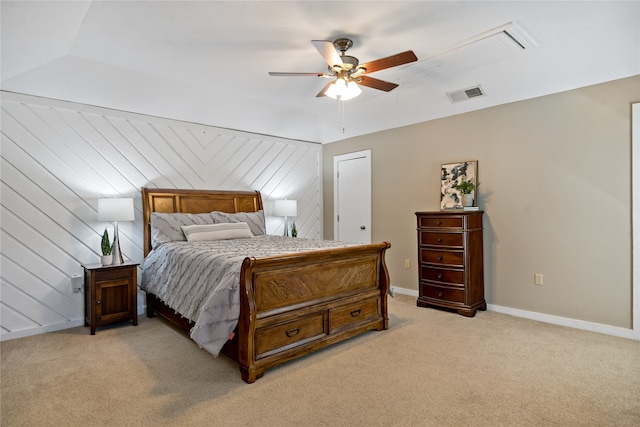 carpeted bedroom featuring wooden walls and ceiling fan