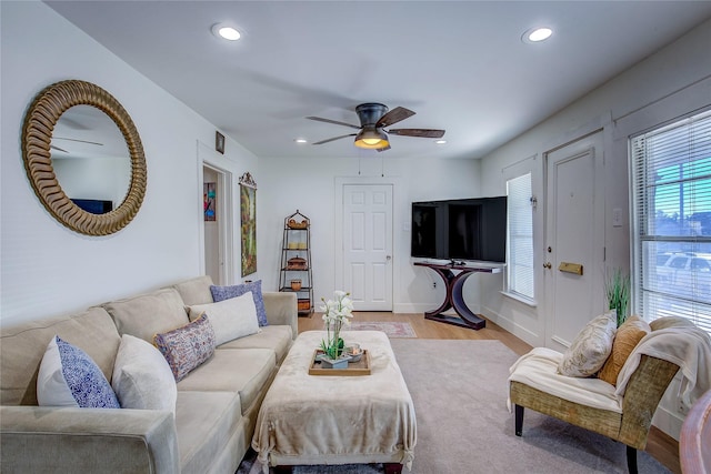 living room featuring ceiling fan, a healthy amount of sunlight, and light wood-type flooring