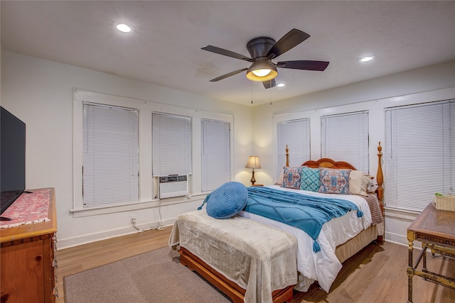 bedroom featuring ceiling fan, cooling unit, and light hardwood / wood-style floors