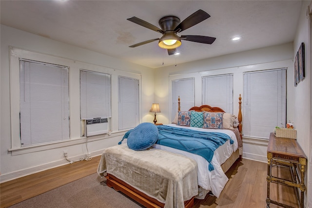 bedroom with ceiling fan, cooling unit, and light wood-type flooring