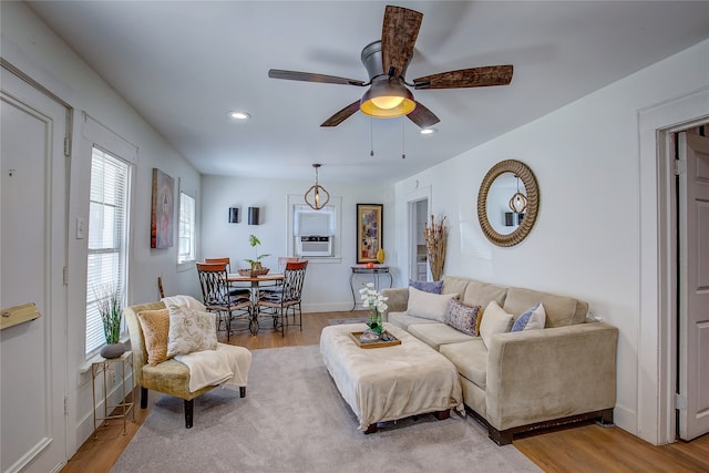 living room with ceiling fan, cooling unit, and hardwood / wood-style flooring