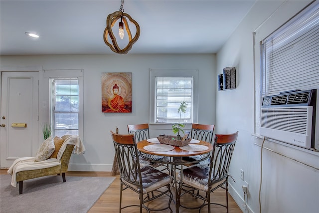 dining space with light hardwood / wood-style floors and cooling unit