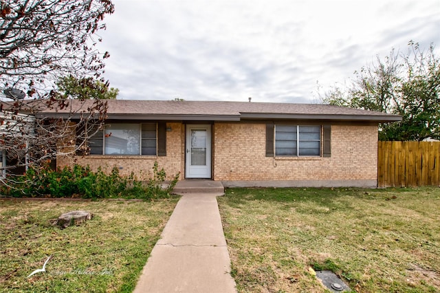 single story home featuring brick siding, a front lawn, and fence