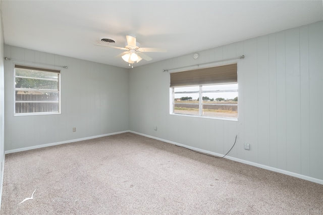 unfurnished room with carpet floors, plenty of natural light, and ceiling fan