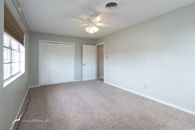 unfurnished bedroom featuring a closet, carpet, and ceiling fan