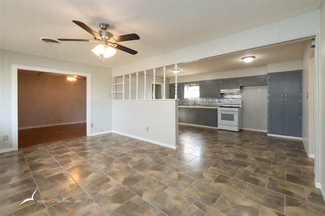 kitchen featuring white range with gas stovetop, ceiling fan, gray cabinetry, and tasteful backsplash