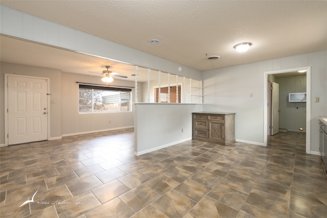 kitchen with ceiling fan and a textured ceiling