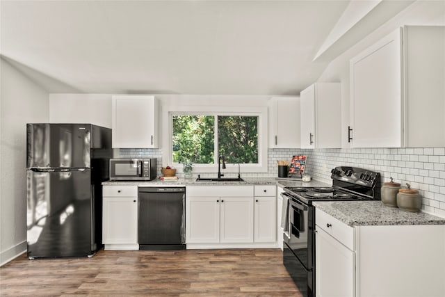 kitchen featuring light stone countertops, sink, black appliances, and white cabinetry