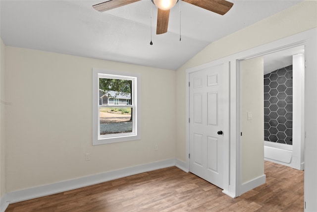 unfurnished bedroom with ceiling fan, lofted ceiling, and hardwood / wood-style floors