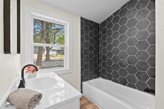 bathroom featuring vanity, hardwood / wood-style flooring, and a bath