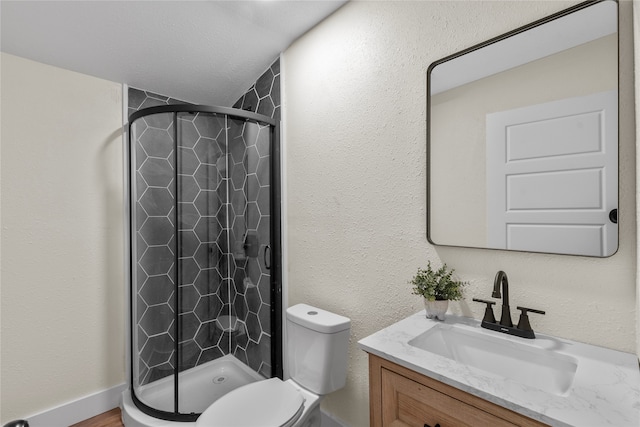 bathroom featuring vanity, toilet, a textured ceiling, and an enclosed shower