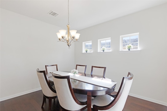 dining room with dark wood-type flooring and a chandelier