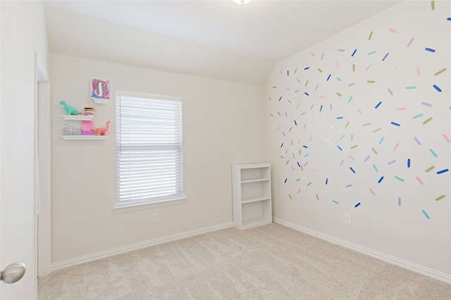 unfurnished room with light colored carpet and vaulted ceiling