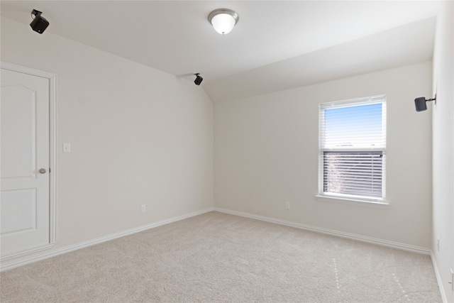 unfurnished room featuring light colored carpet and lofted ceiling