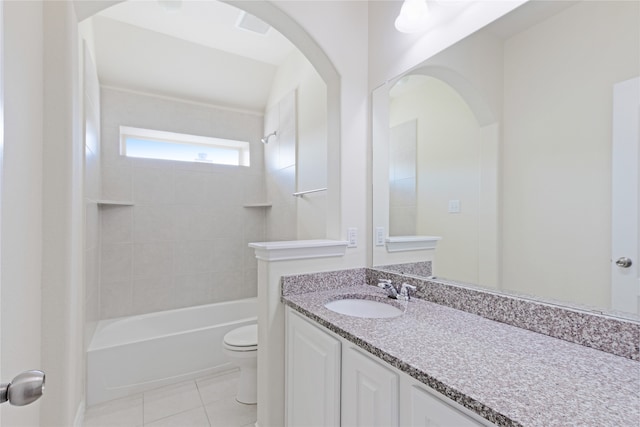 full bathroom with tile patterned flooring, vanity, tiled shower / bath combo, and toilet