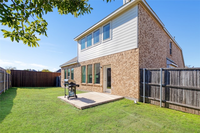 back of house featuring a lawn and a patio area