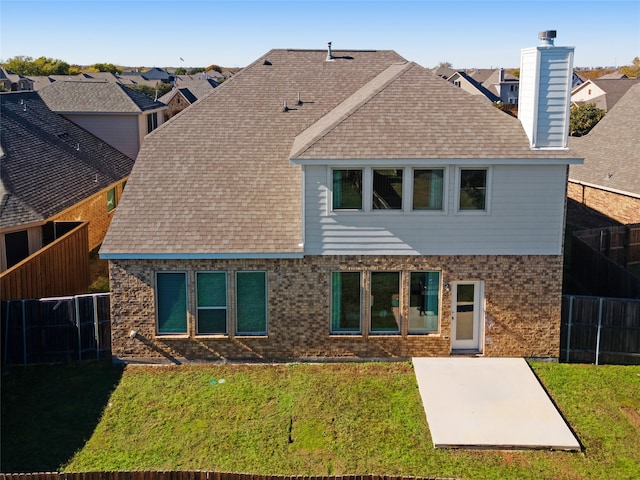 rear view of property featuring a lawn and a patio