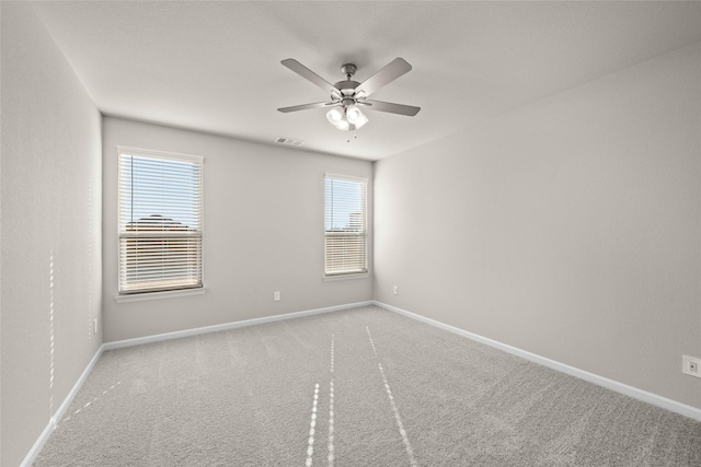 carpeted spare room with ceiling fan