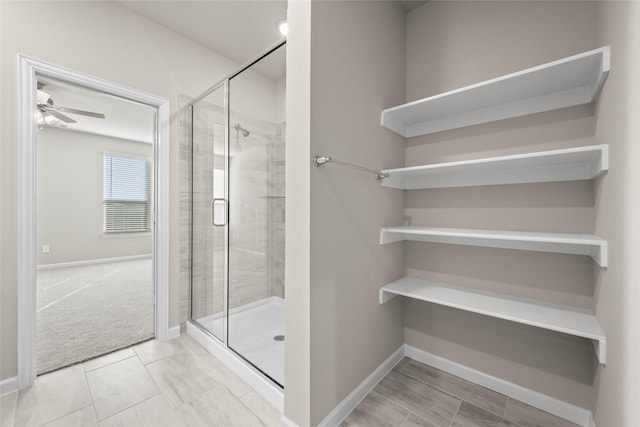 bathroom with a shower with door, tile patterned flooring, and ceiling fan