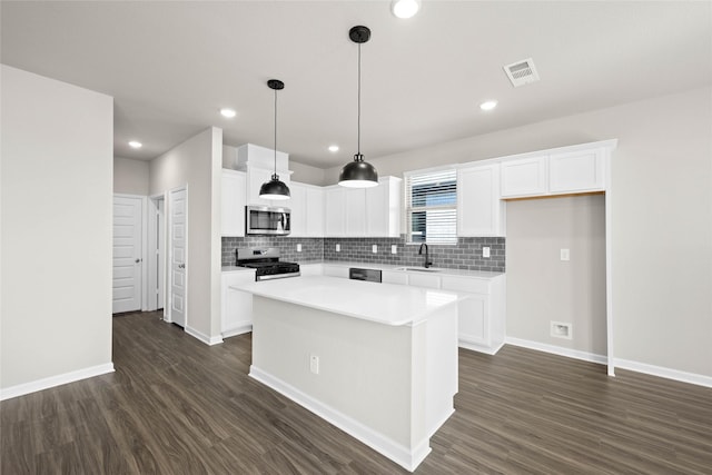 kitchen with a kitchen island, appliances with stainless steel finishes, sink, and white cabinets