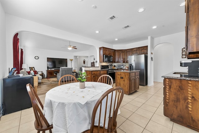 dining area with ceiling fan, light tile patterned floors, and sink