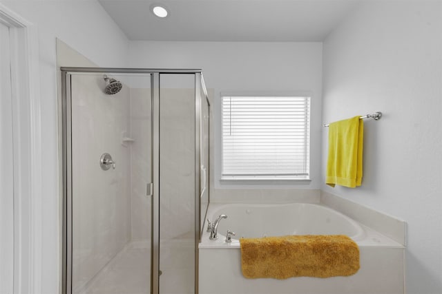 bathroom featuring plenty of natural light and shower with separate bathtub