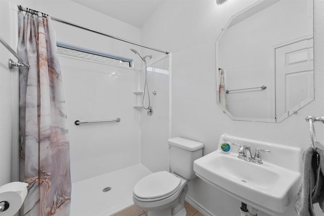 bathroom with curtained shower, sink, and toilet