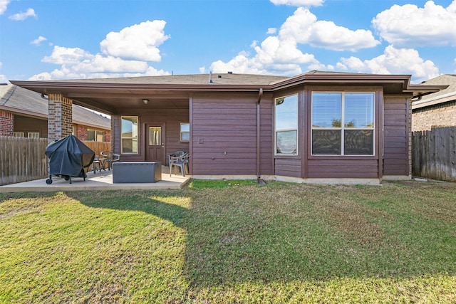 rear view of property with a lawn and a patio