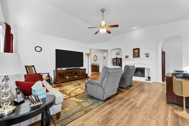 living room featuring wood-type flooring, vaulted ceiling, and ceiling fan