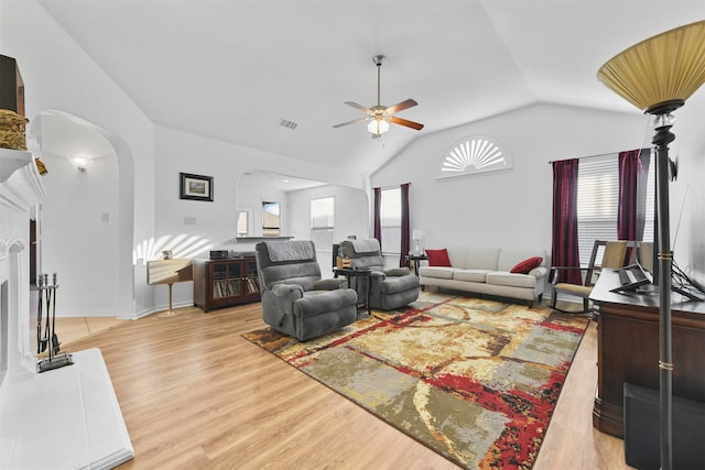 living room featuring light hardwood / wood-style floors, vaulted ceiling, and ceiling fan