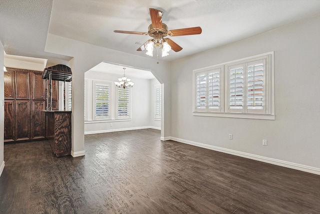 unfurnished living room featuring a textured ceiling, ceiling fan with notable chandelier, and dark hardwood / wood-style flooring