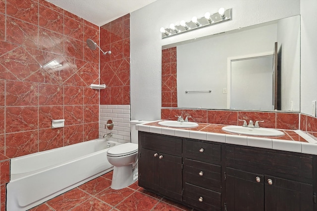 full bathroom featuring tile walls, vanity, tiled shower / bath combo, and toilet