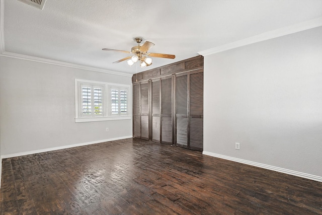 unfurnished bedroom with dark hardwood / wood-style flooring, crown molding, a closet, and ceiling fan