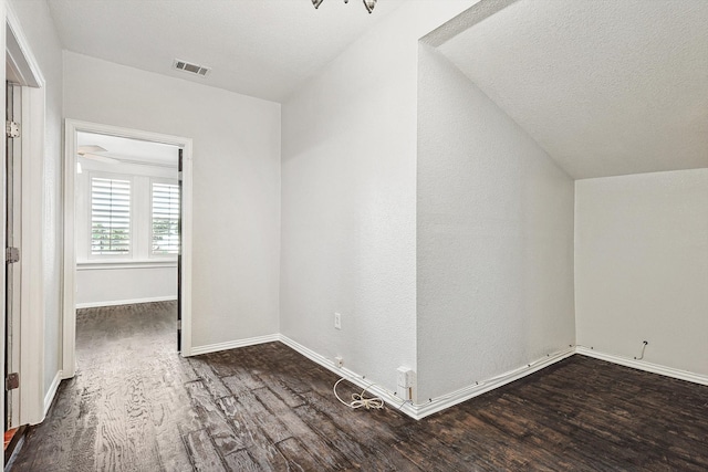 bonus room featuring lofted ceiling, a textured ceiling, and dark hardwood / wood-style flooring